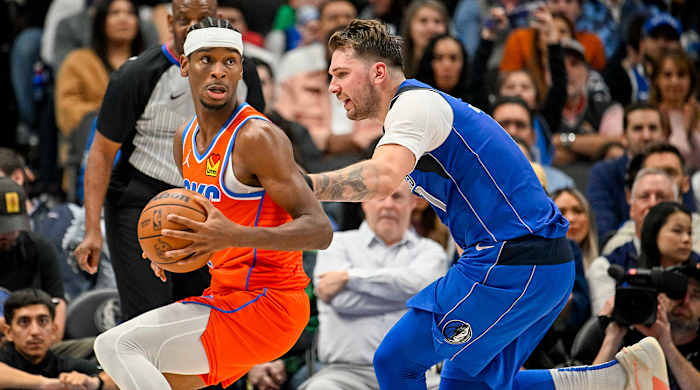 Oklahoma City Thunder guard Shai Gilgeous-Alexander possesses the ball against Dallas Mavericks guard Luka Doncic